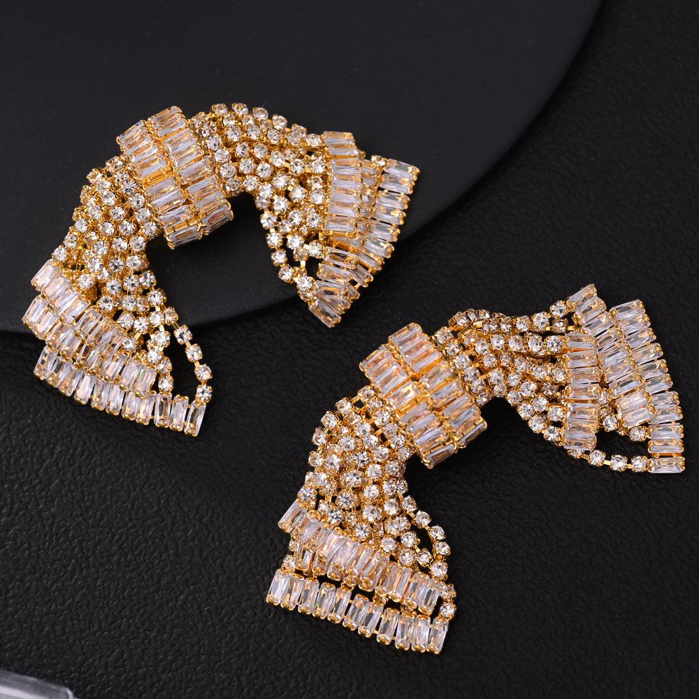 Pair of gold and crystal earrings on a black background