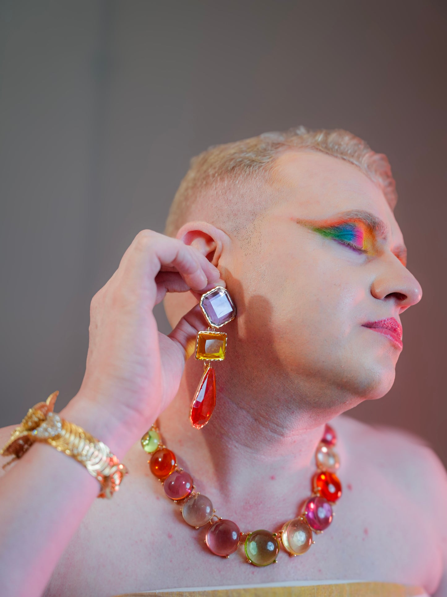 Person wearing colorful jewelry with a neutral background