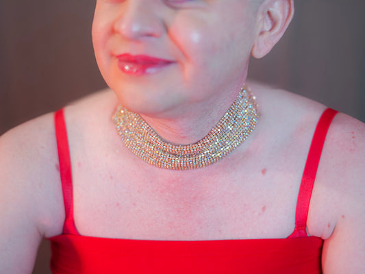Person wearing the Joyen Choker Necklace—an elaborate, multi-layered crystal choker styled with a red spaghetti strap top and red lipstick