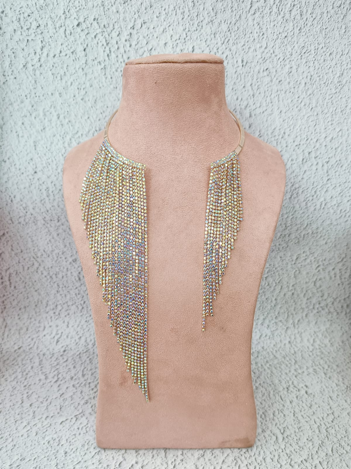 Beaded necklace on a mannequin bust against a textured gray background