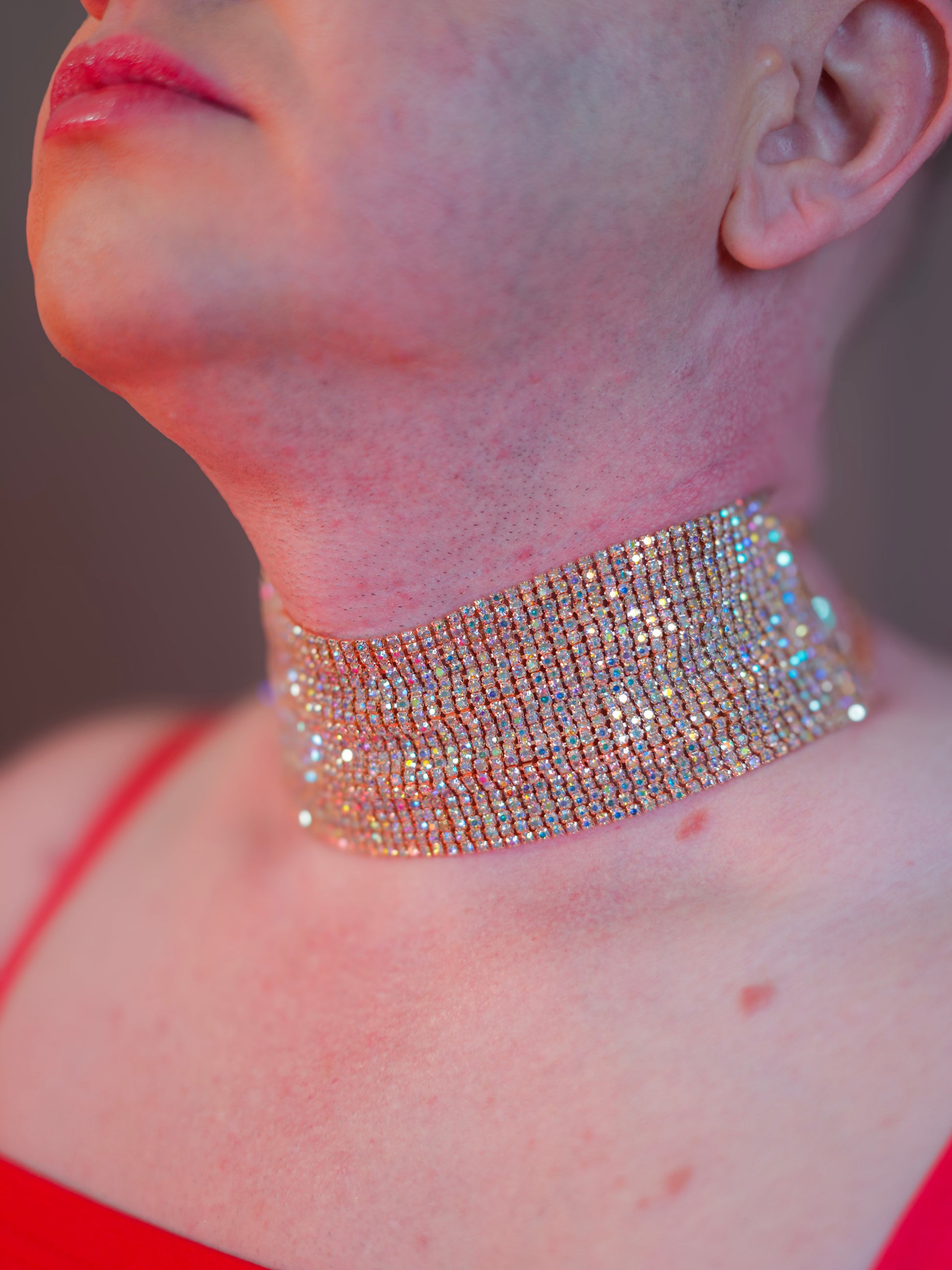 Close-up of a person wearing a sparkling choker necklace.