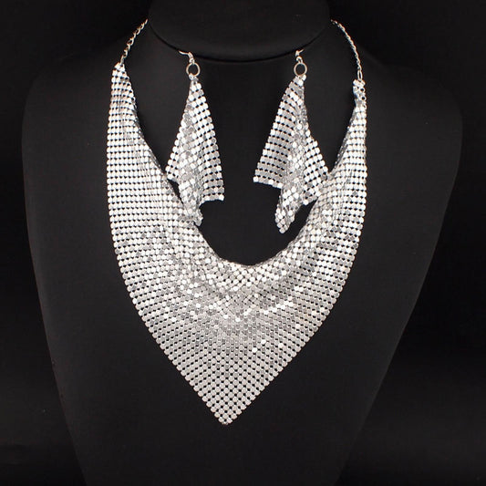 Silver mesh triangle necklace and matching earrings displayed on black bust – statement jewelry set for formal or pride occasions.