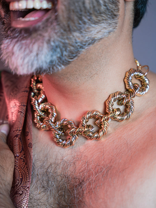 Close-up of the Tolyn gold chain necklace worn around the neck, showcasing its intricate design and bold elegance